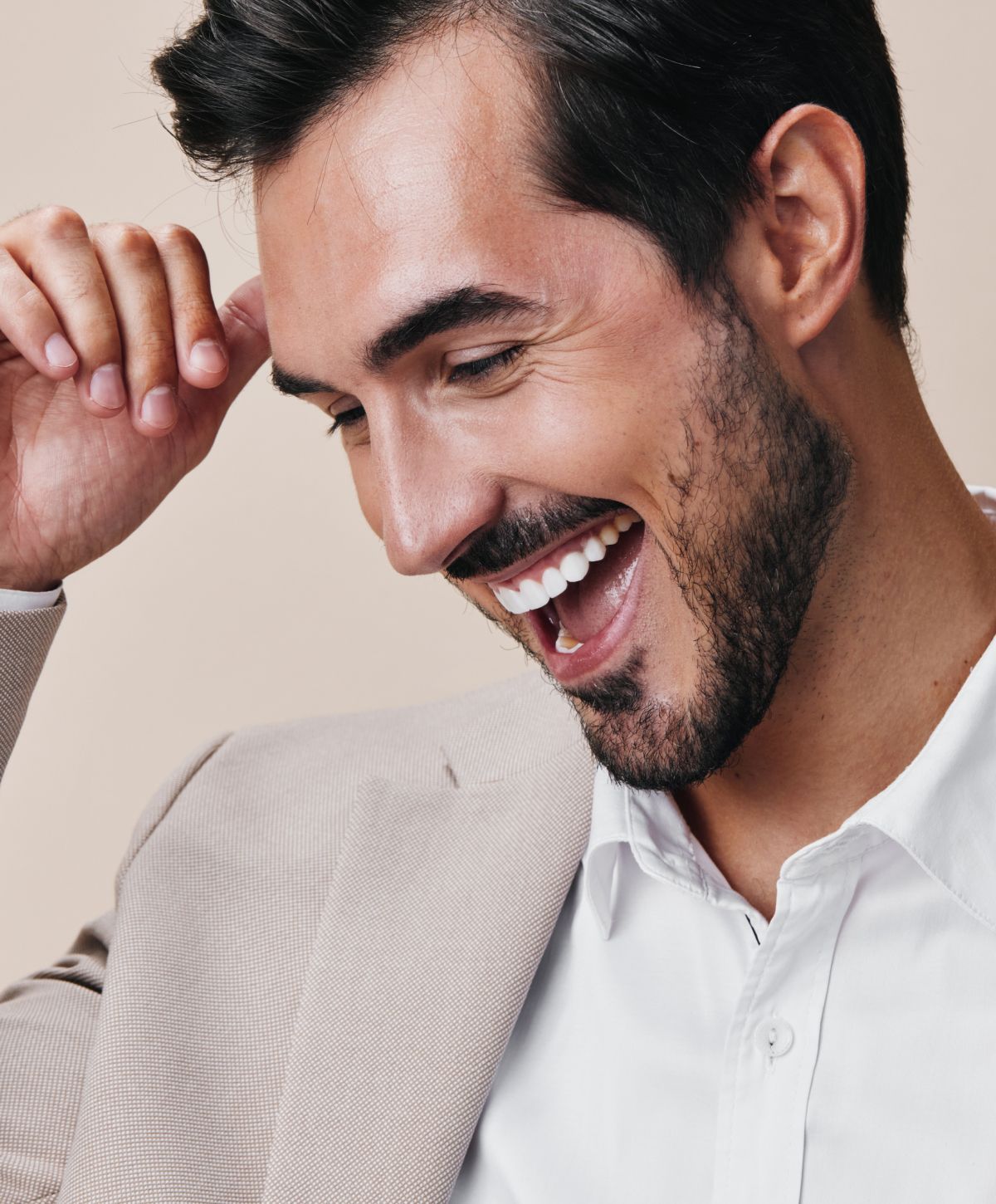 Smiling man in a light suit and shirt.